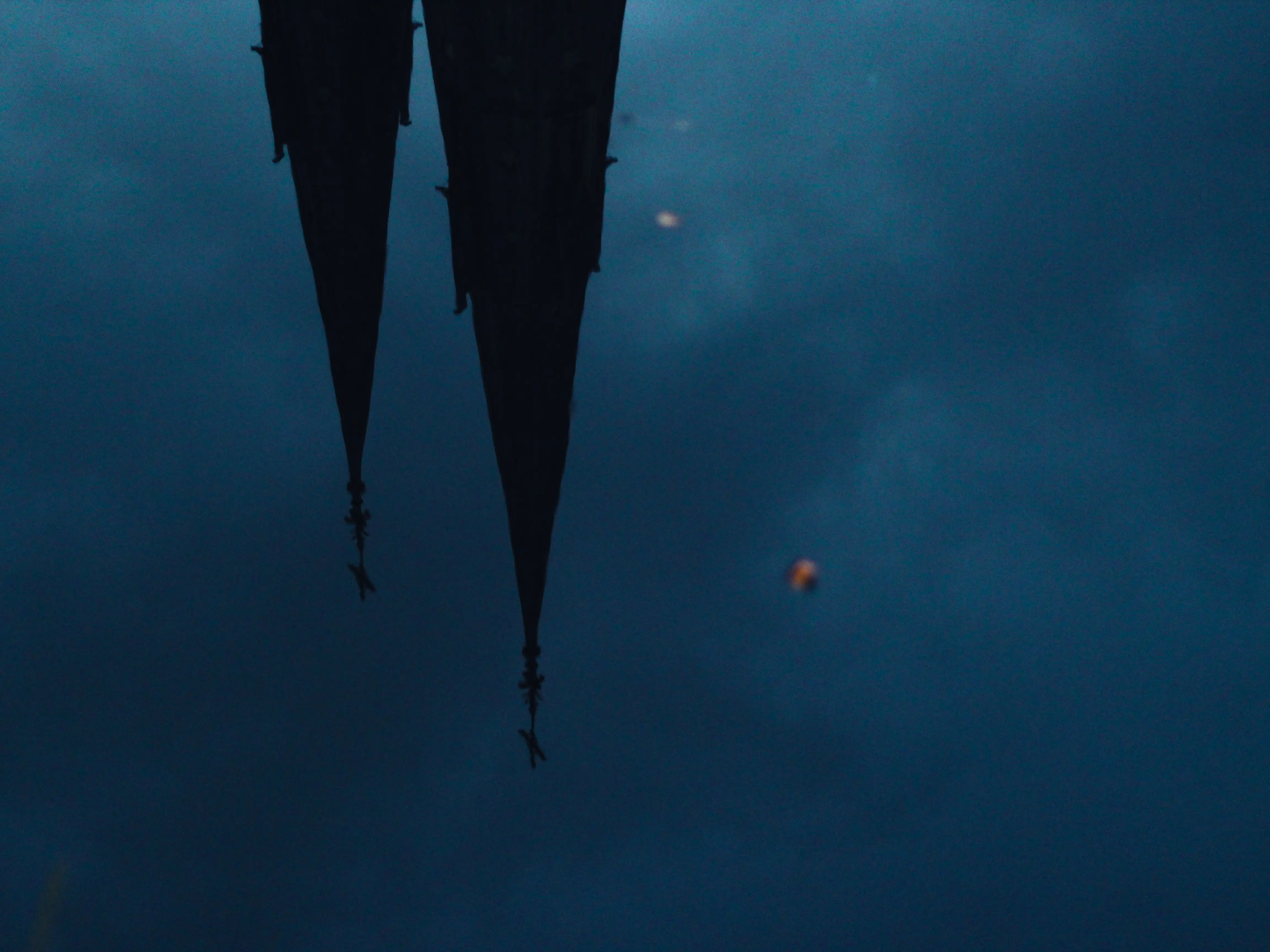 a photo taken of a reflection of the two spires of Uppsala Cathedral in the river Fyris