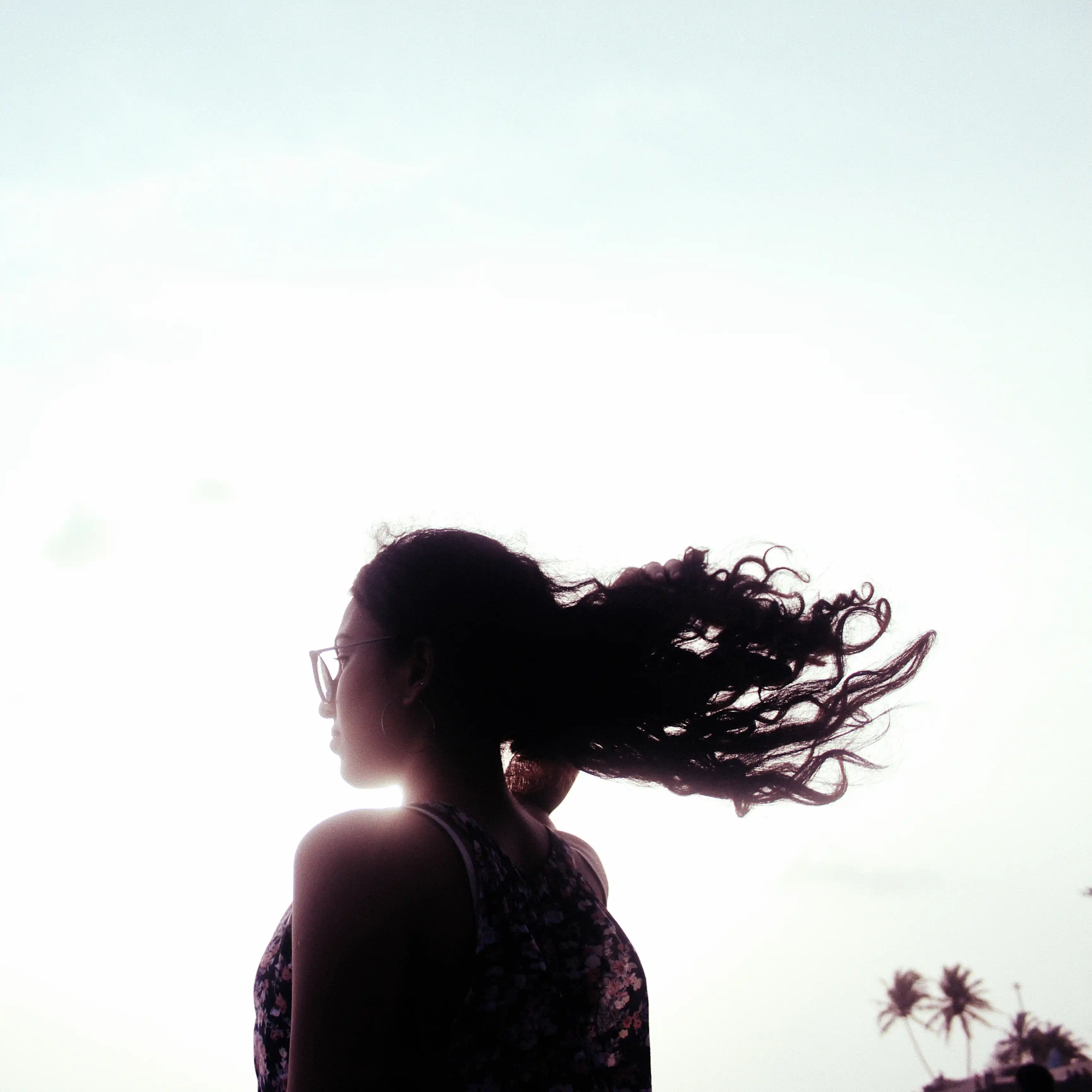silhouette of a girl's curly hair flying in the wind at Uttan beach in Mumbai