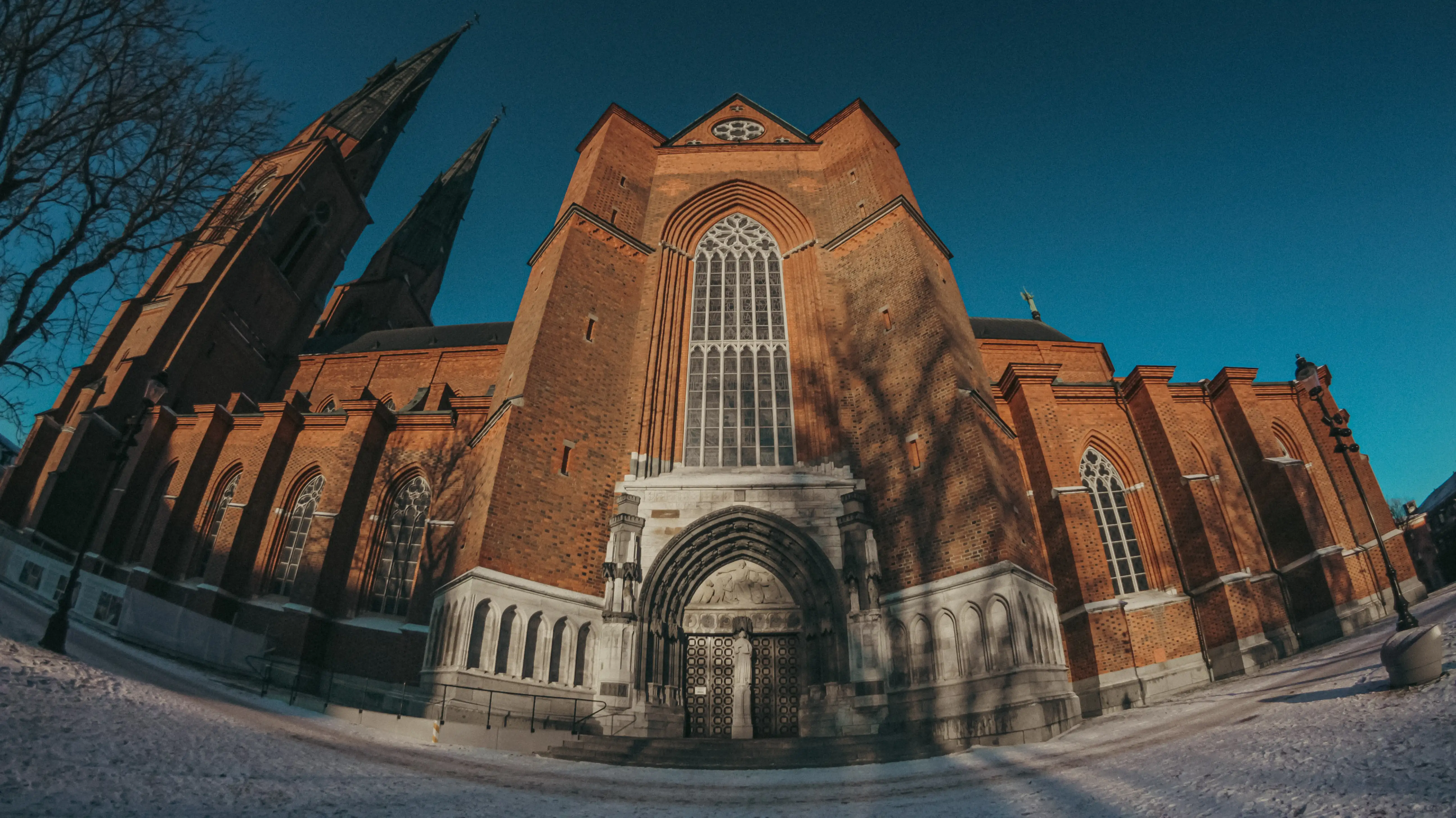 a wide angle shot of the side entrance of Uppsala Cathedral during winter time