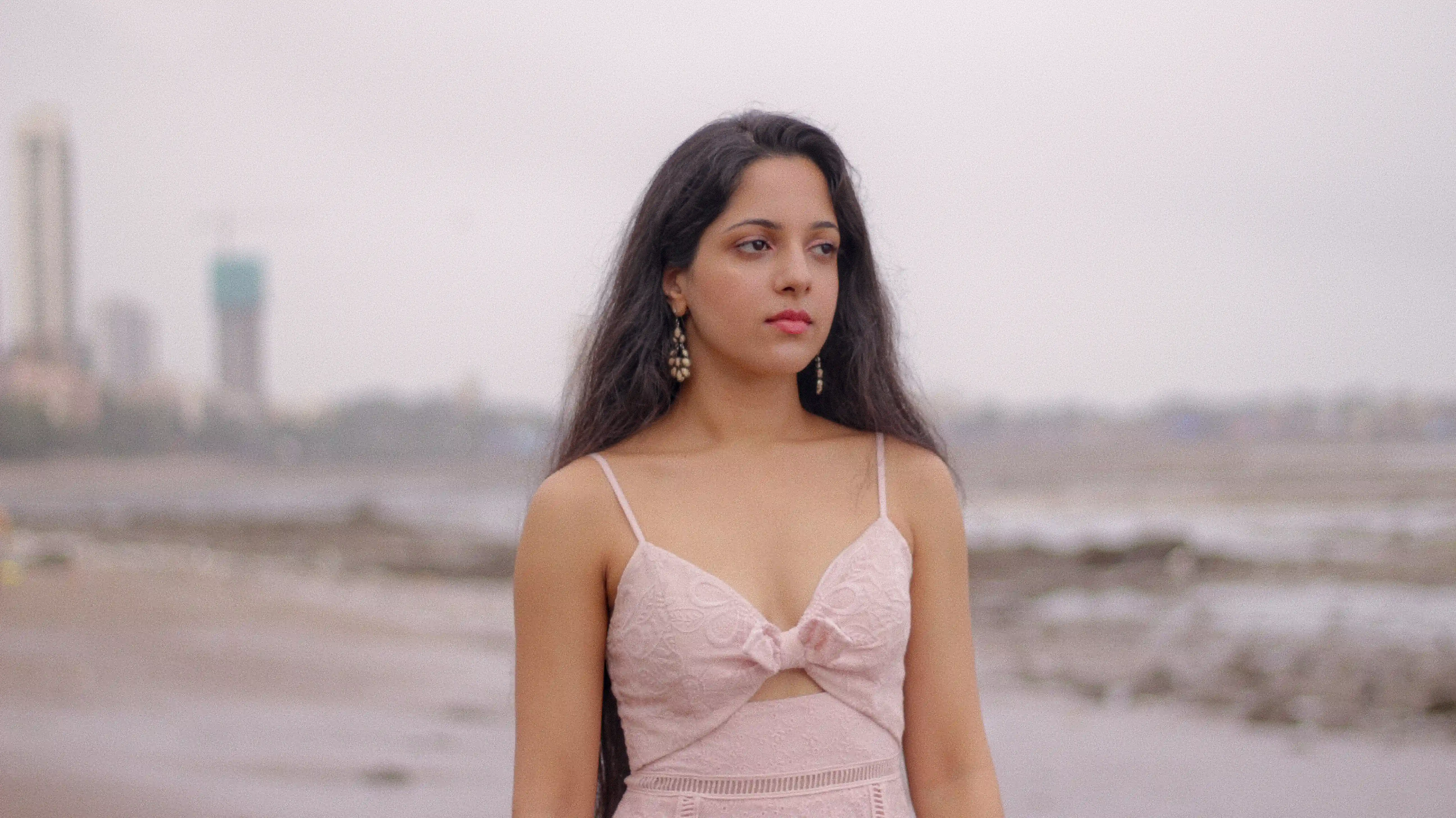 aa photoshoot with social media influencer Avanti Nagral at Dadar Chowpatty in Mumbai where she is wearing a pink dress and standing against the pink early morning sky