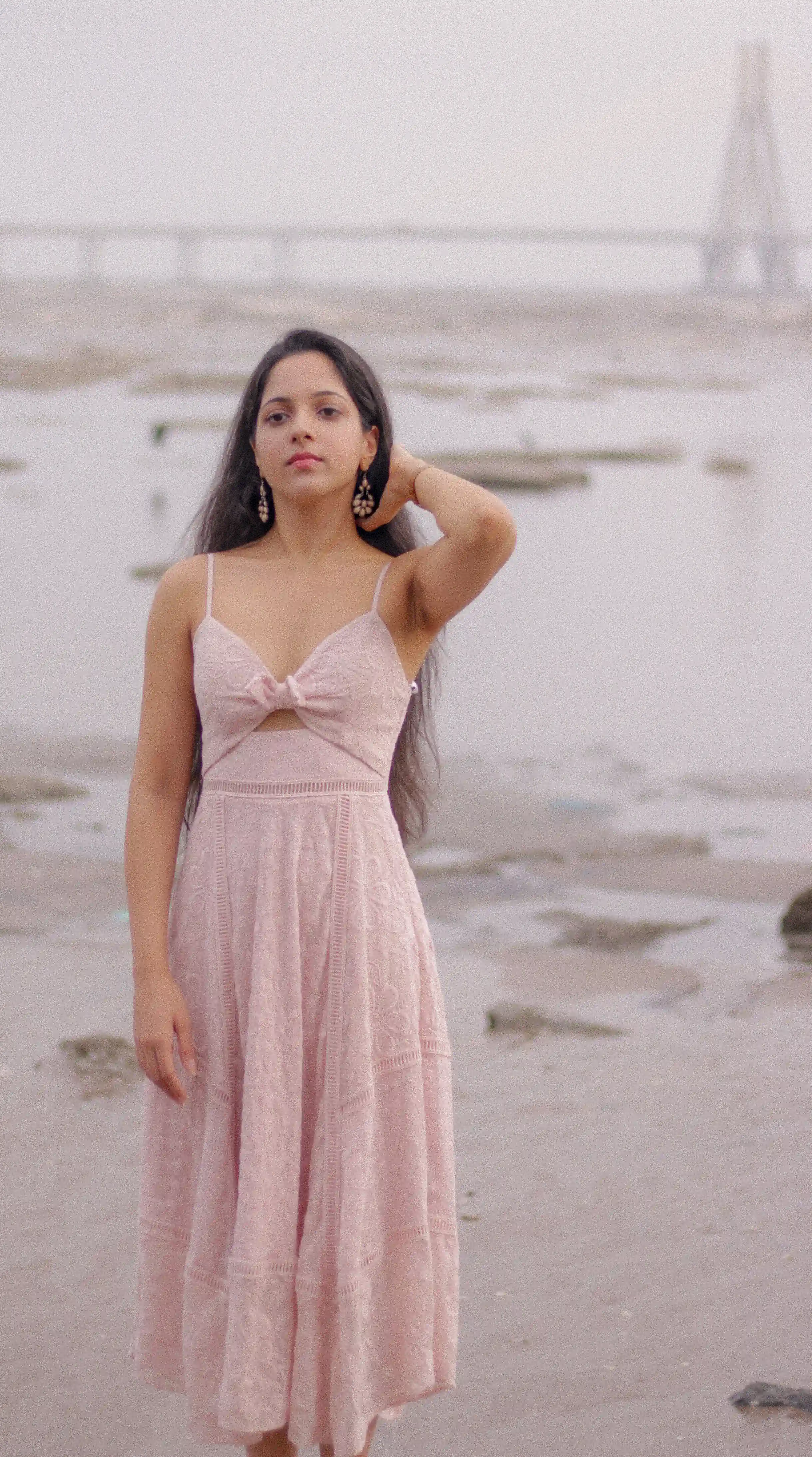 a photoshoot with social media influencer Avanti Nagral at Dadar Chowpatty in Mumbai where she is wearing a pink dress and standing against the pink early morning sky