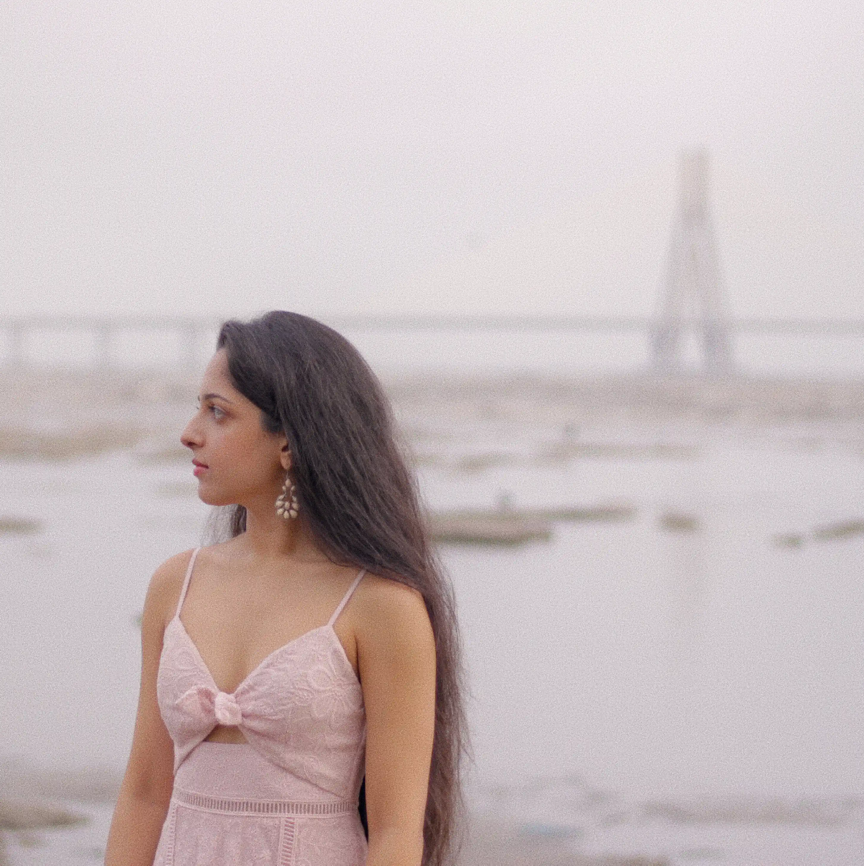 a photoshoot with social media influencer Avanti Nagral at Dadar Chowpatty in Mumbai where she is wearing a pink dress and standing against the pink early morning sky