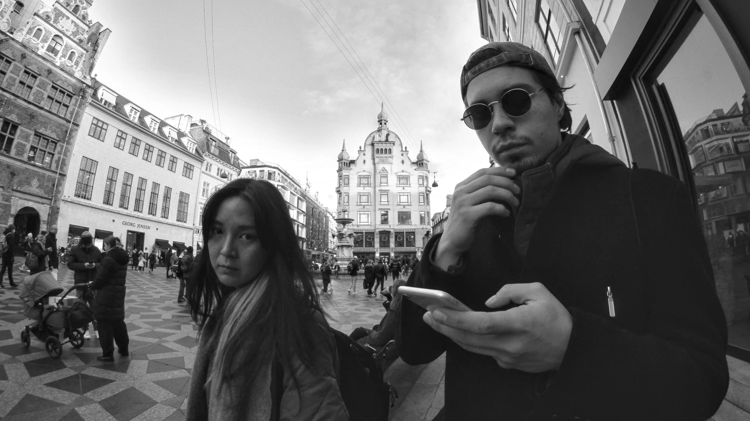 a photo take  on a high street in Copenhagen with a man and a woman posing for the camera.