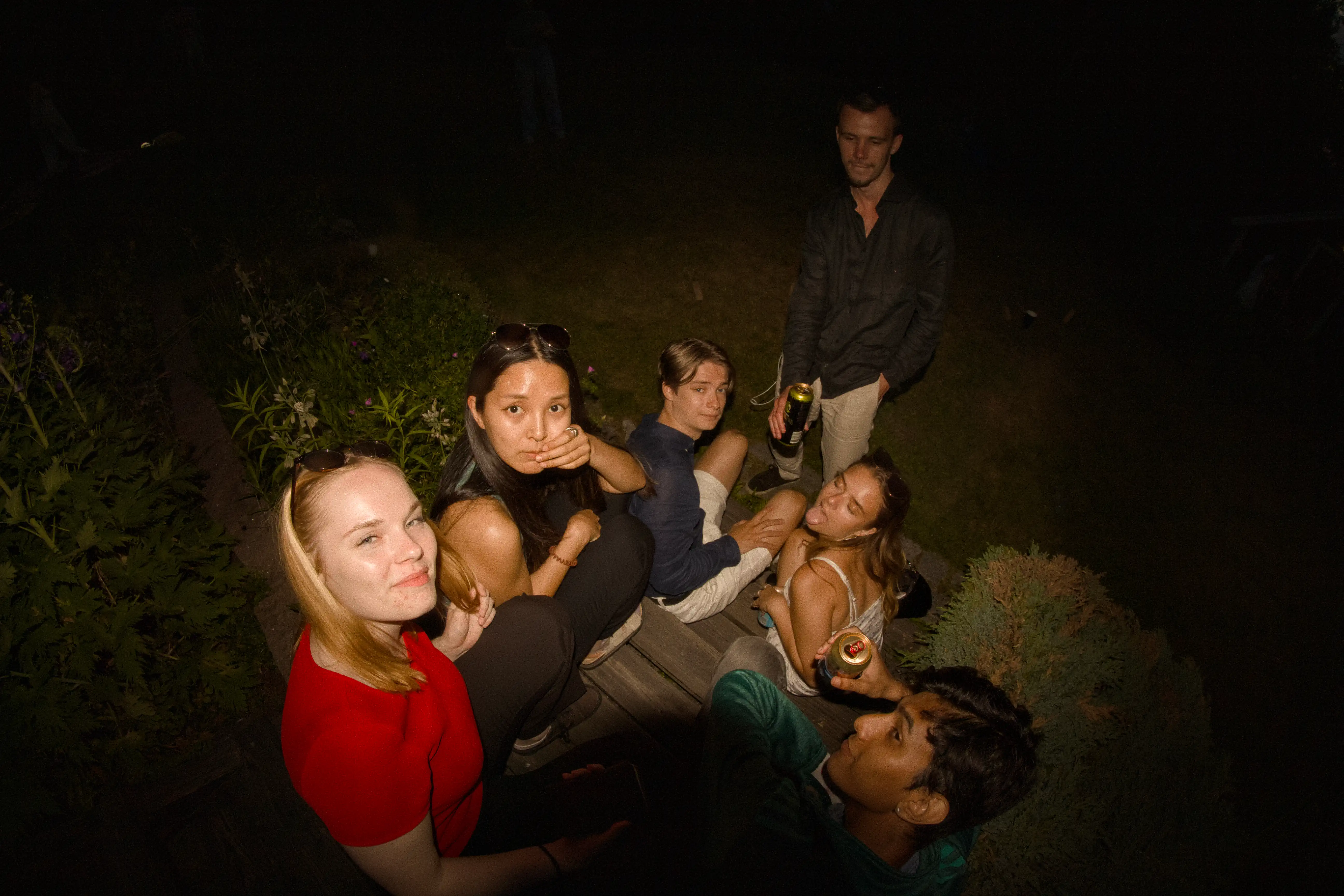 A group of friends sitting down and posing for a photo during Midsommar celebrations
