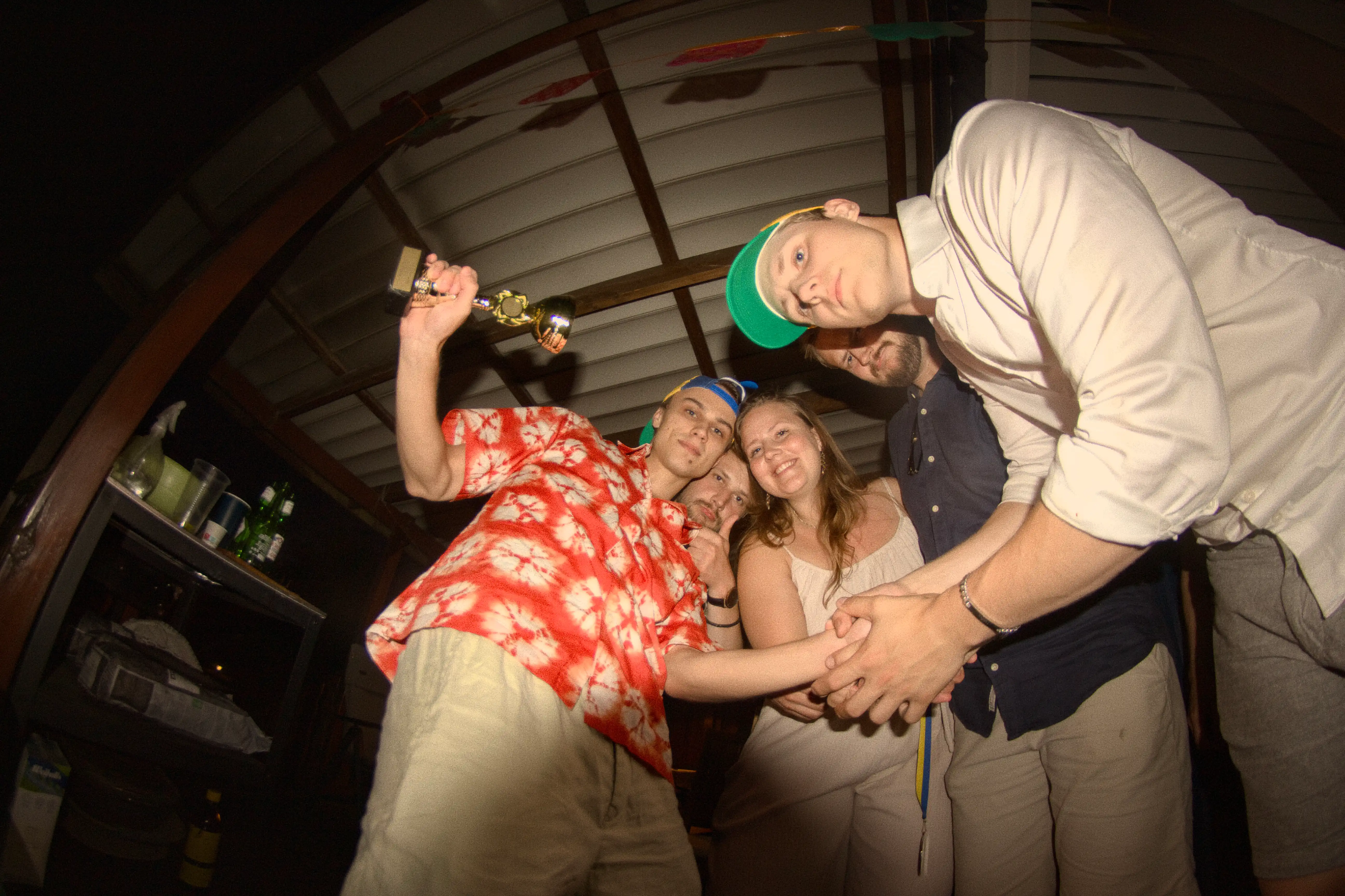 A group of friends holding hands and posing for a photo during Midsommar