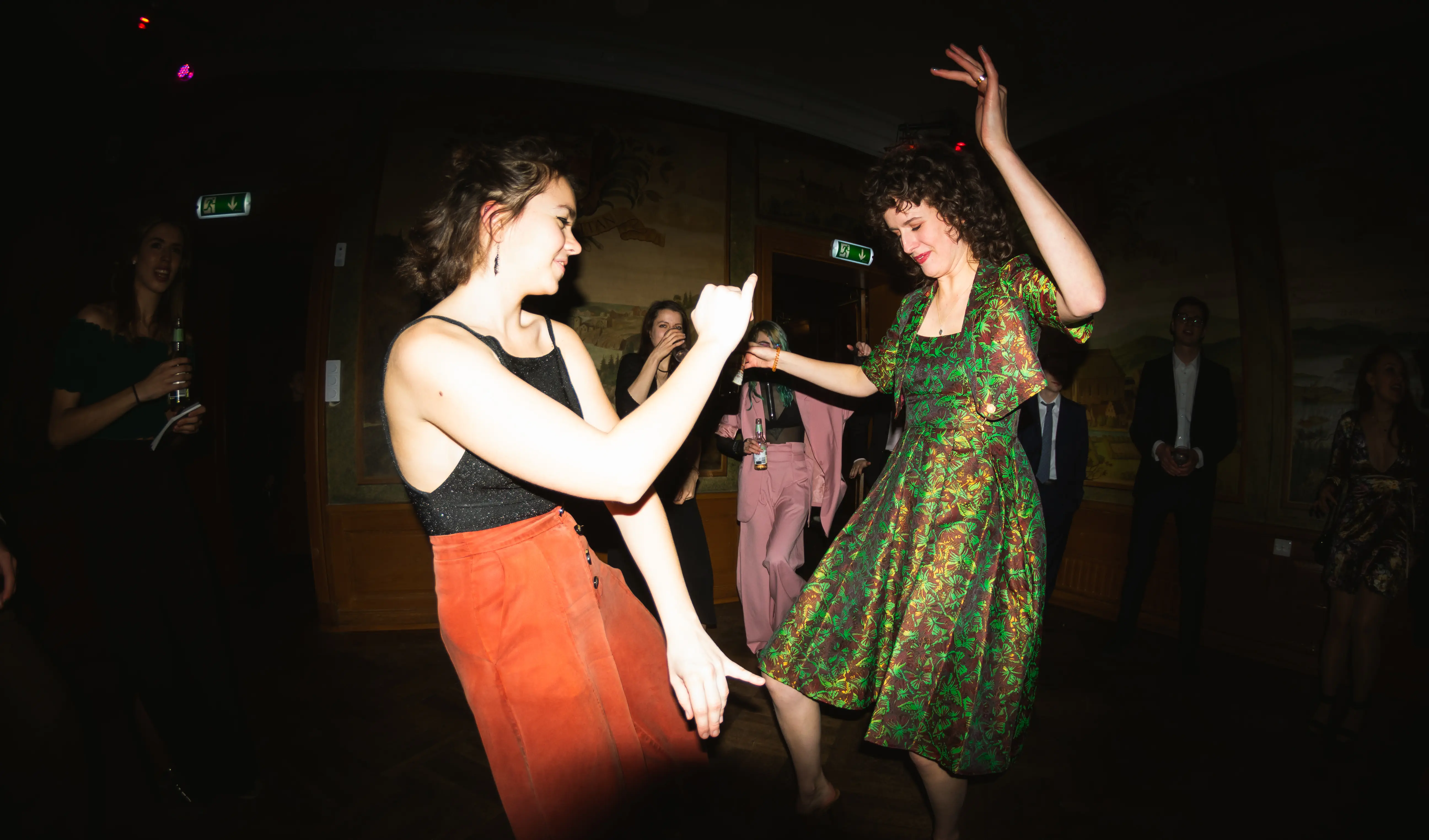 Two women, facing each other and dancing at Västgöta Nation, Uppsala