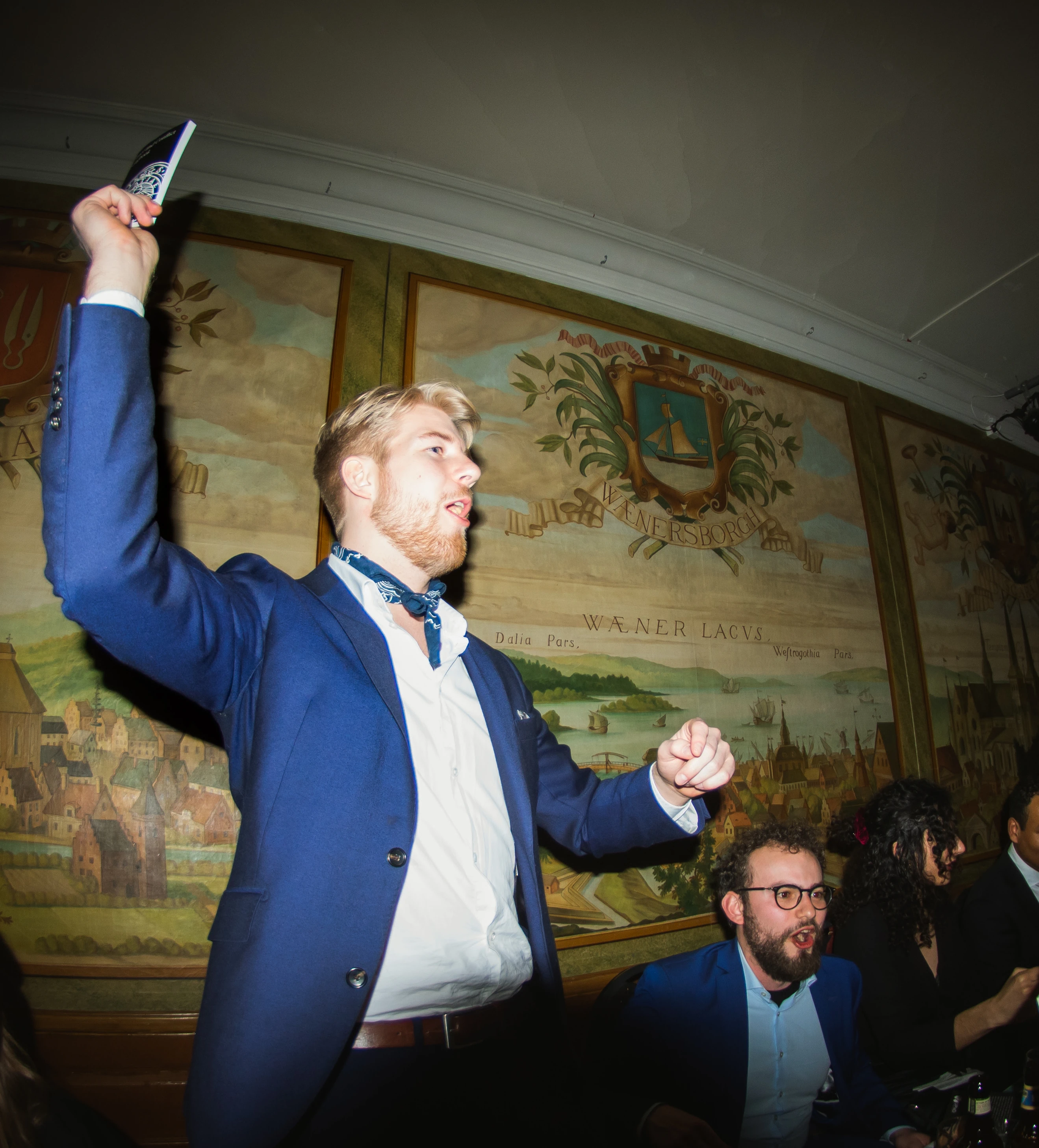 A man singing with a songbook in his hand, at Väsgöta Nation, Uppsala