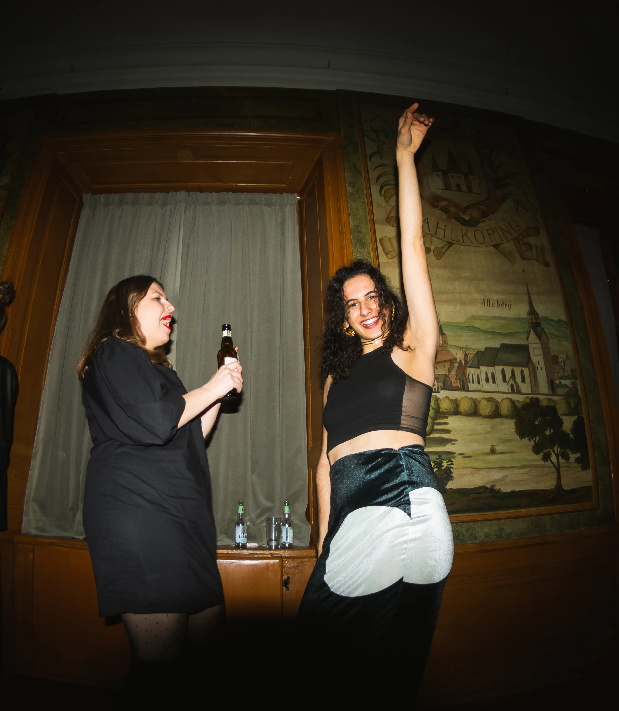 Two women dancing in a dimly lit room at Västgöta Nation, Uppsala