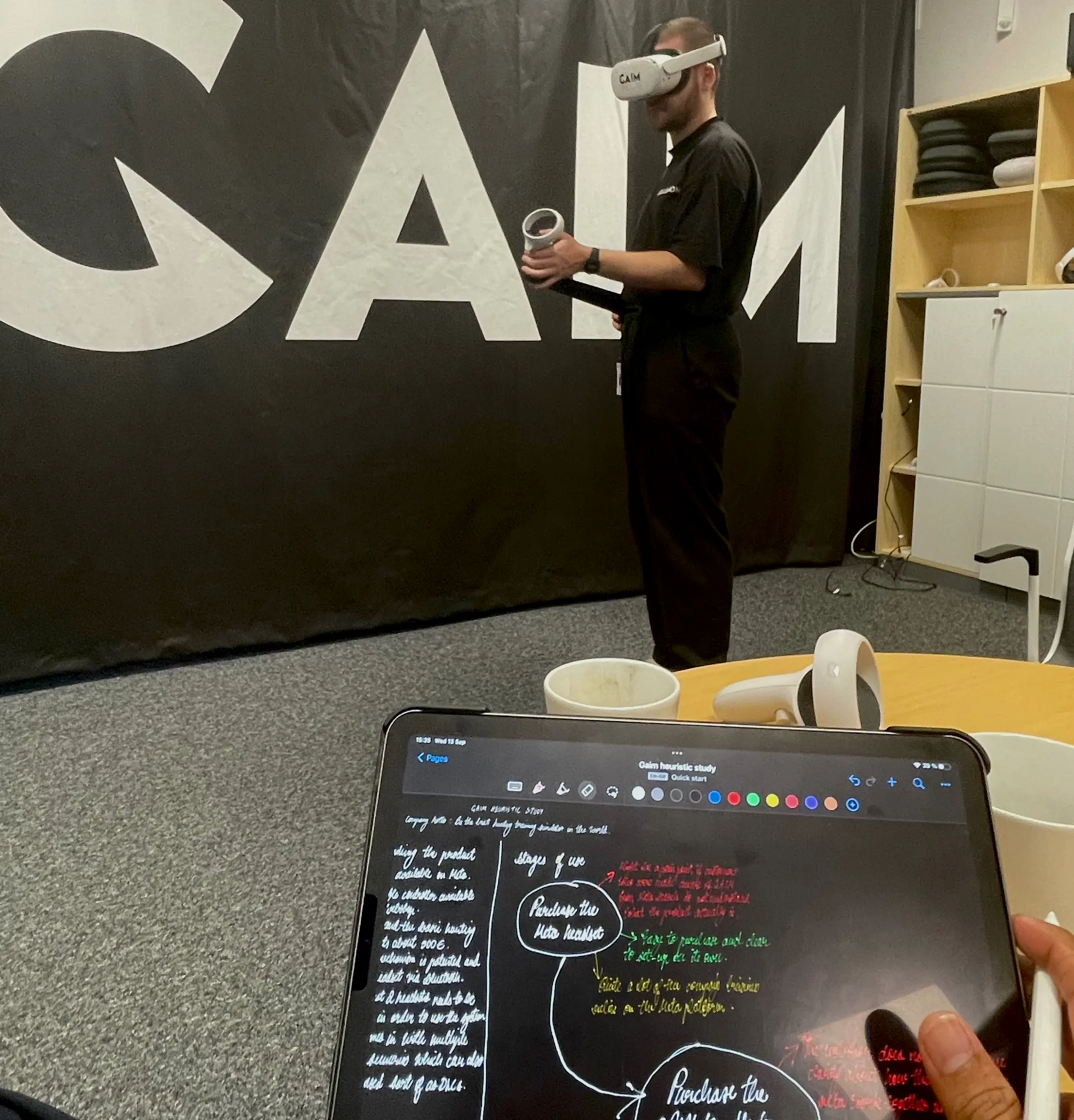 A team member at GAIM, using the rifle controller and meta headset while another takes down notes.